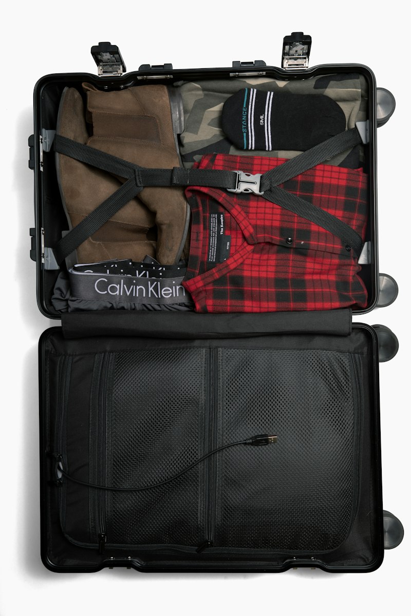 Valise ouverte avec des vêtements pliés et sanglés
